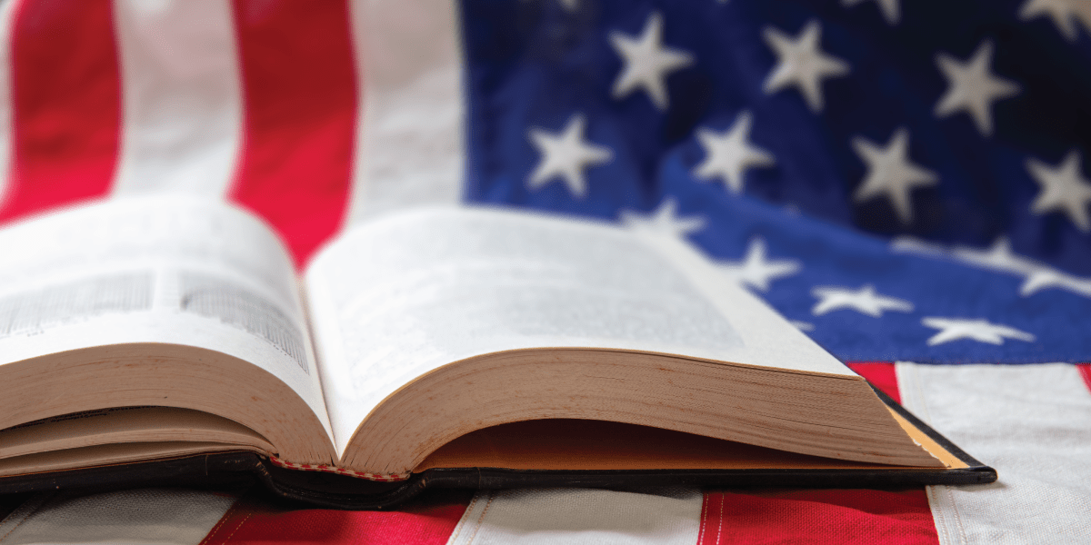 an open book laying on an American flag
